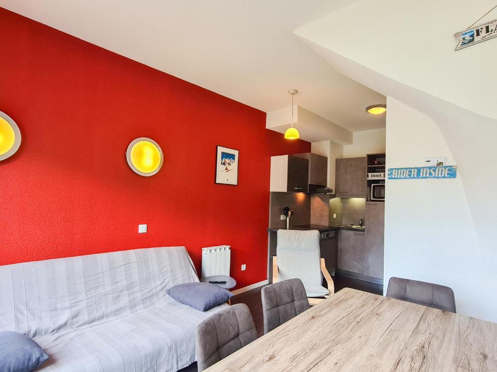 een eetkamer met een tafel en een rode muur bij Appartement Flaine, 3 pièces, 6 personnes - FR-1-425-138 in Flaine