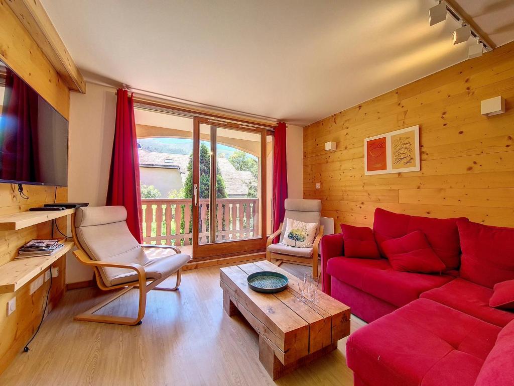a living room with a red couch and a table at Appartement en duplex, 3 pièces, au pied des pistes, balcon, casier à ski, classé 3 flocons or - FR-1-344-908 in Saint-Martin-de-Belleville