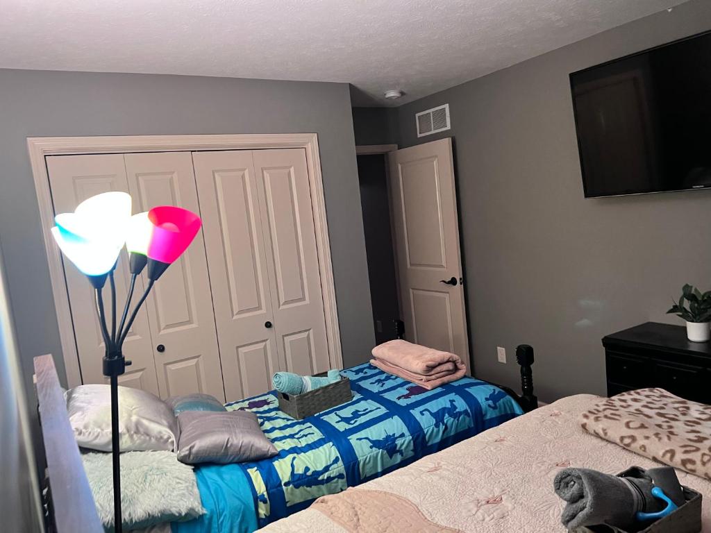 a bedroom with two beds and a lamp in it at Petit Domicile QUEEN & TWIN Beds Main Floor in Lincoln
