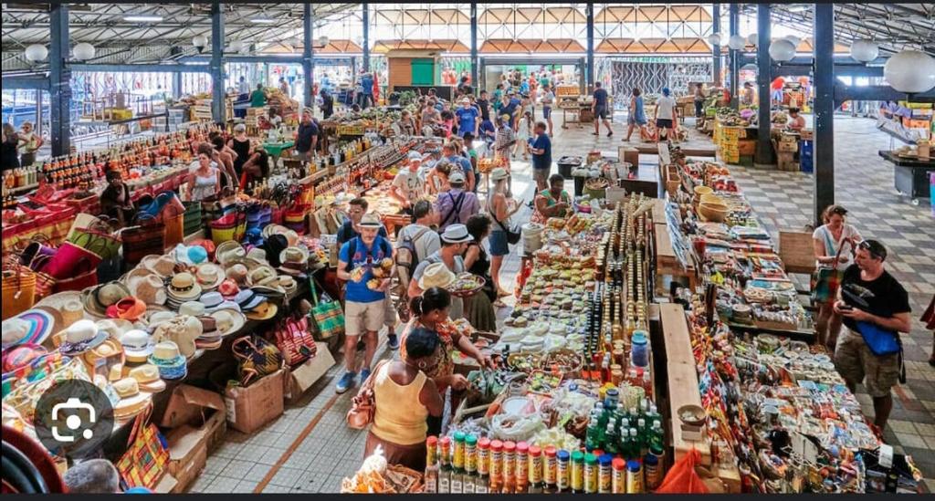 un grupo de personas en un mercado con muchas mesas en Appartement Clos du bois en Fort-de-France