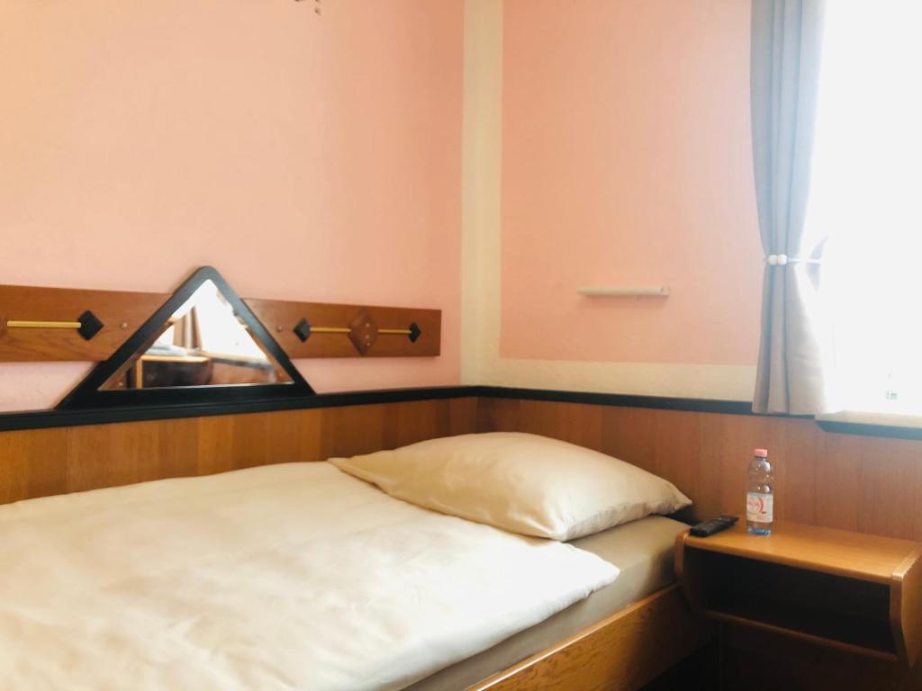 a bedroom with a bed with a mirror and a window at Holmes Café & Pension in Engelhartszell