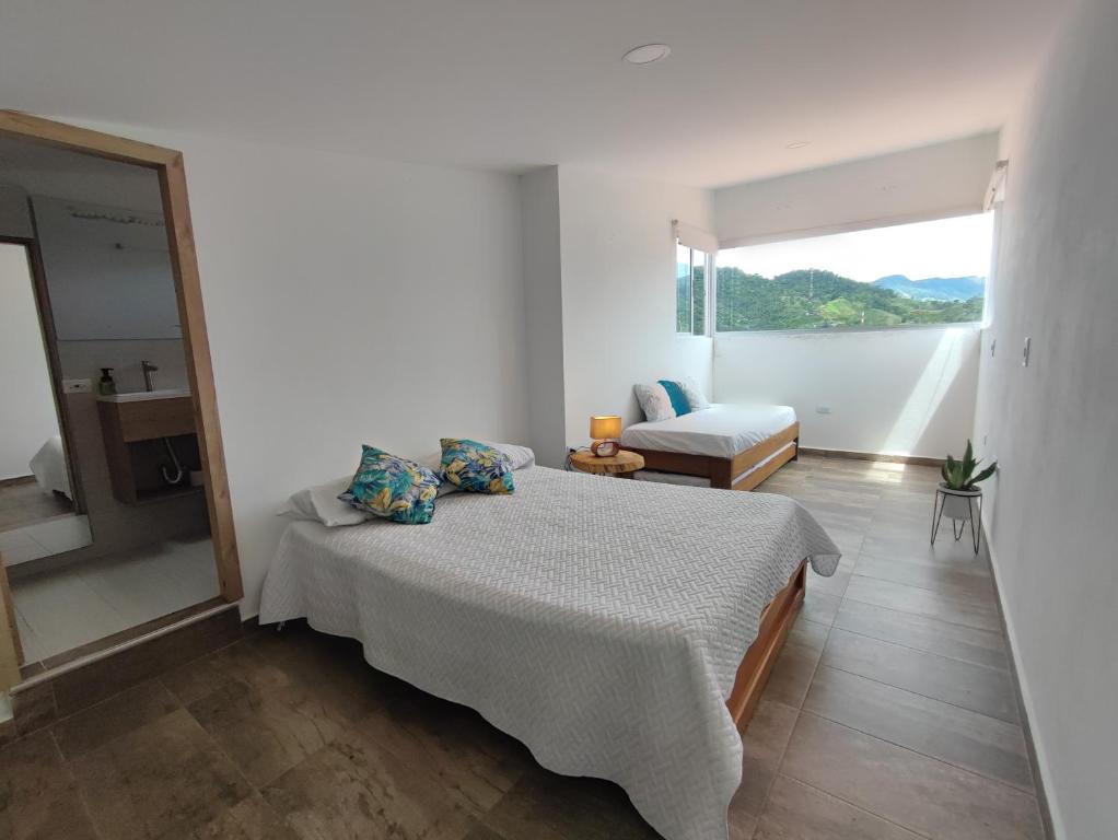 ein weißes Schlafzimmer mit einem Bett und einem Fenster in der Unterkunft Lagom Apartamentos San Rafael in San Rafael