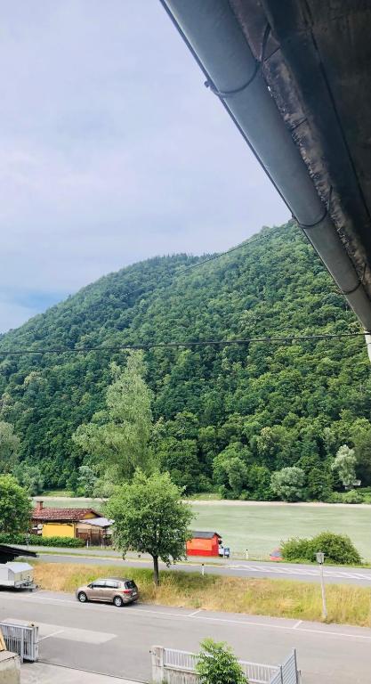 a car driving down a road in front of a mountain at Holmes Café & Pension in Engelhartszell