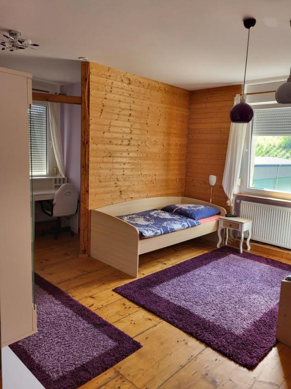 a bedroom with a bed and two purple rugs at Monteurunterkunft Maria in Freital