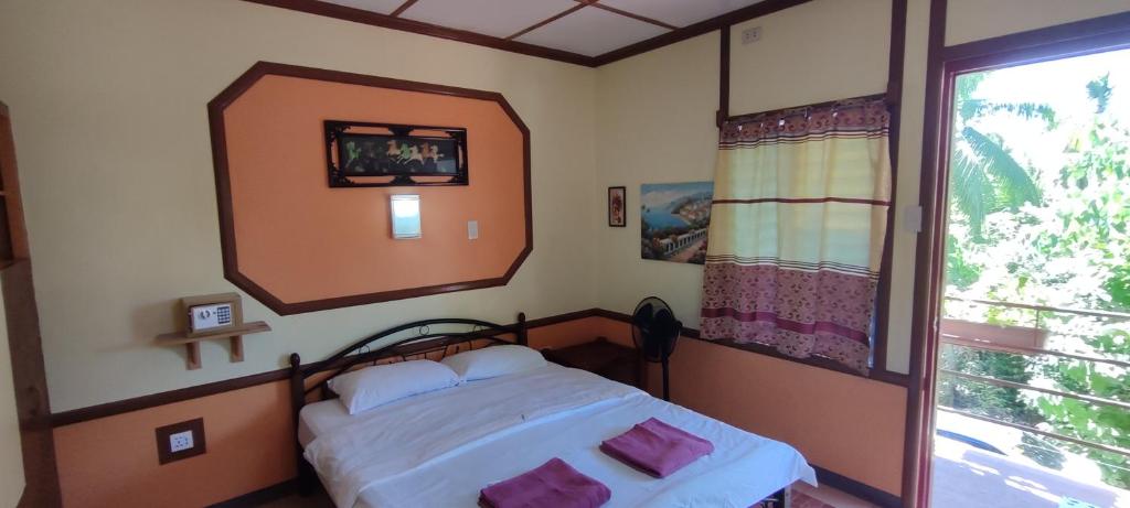 1 dormitorio con 1 cama con espejo grande en Mango House Apartments, en Panglao