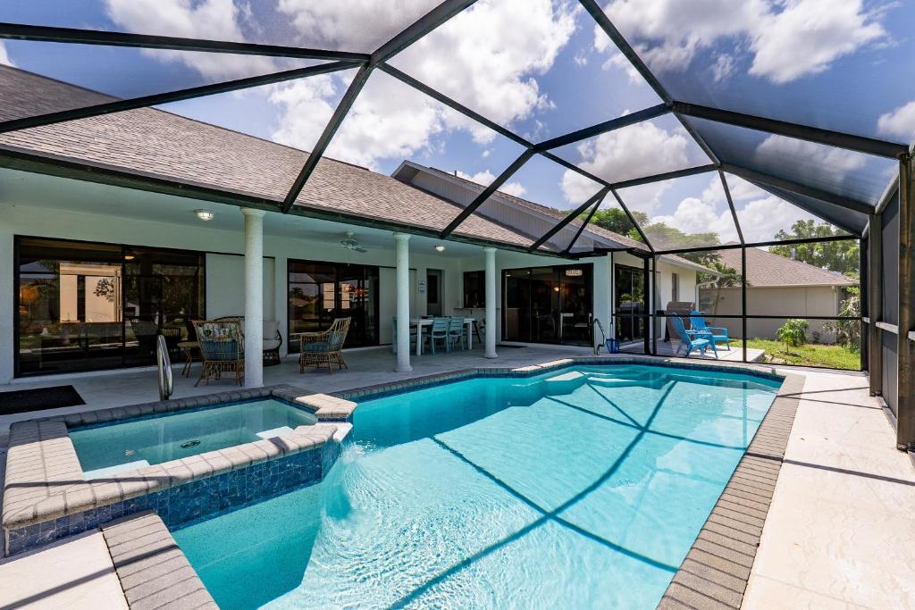 een zwembad in een huis met een glazen dak bij Beautiful Private Pool Home In-between Fort Myers Beach and Sanibel Island home in Fort Myers