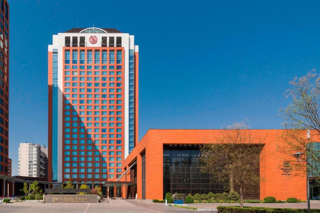 ein hohes Gebäude mit einer Uhr darüber in der Unterkunft Sheraton Hohhot Hotel in Hohhot