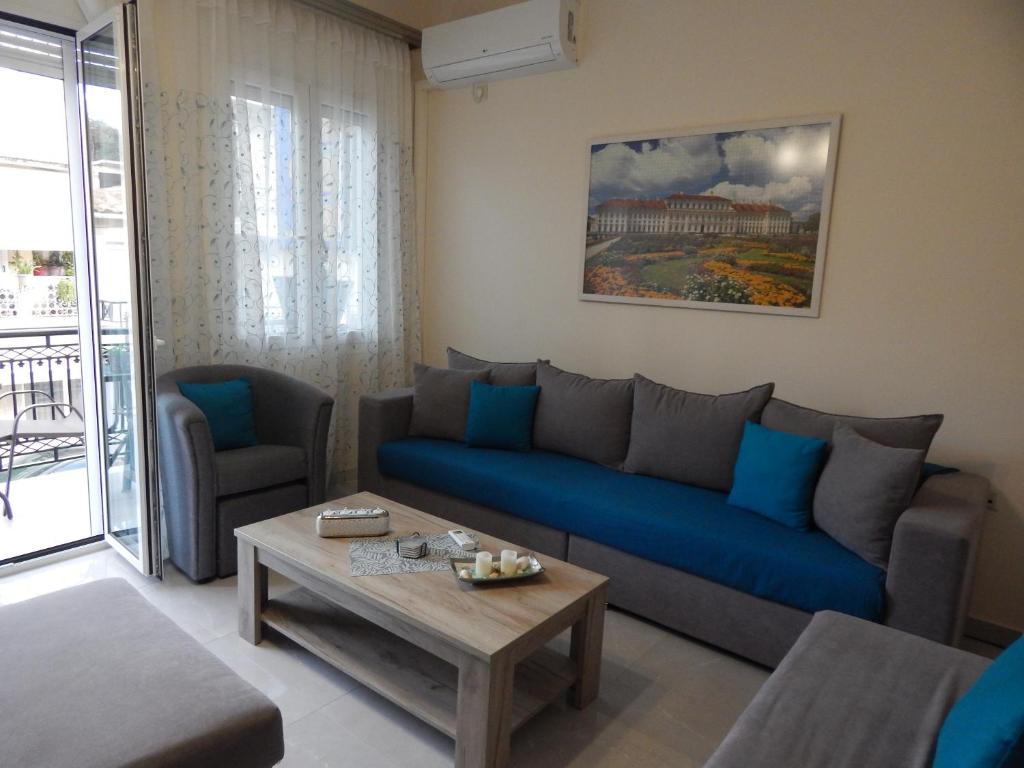 a living room with a blue couch and a table at Vera City Apartment in Zakynthos Town