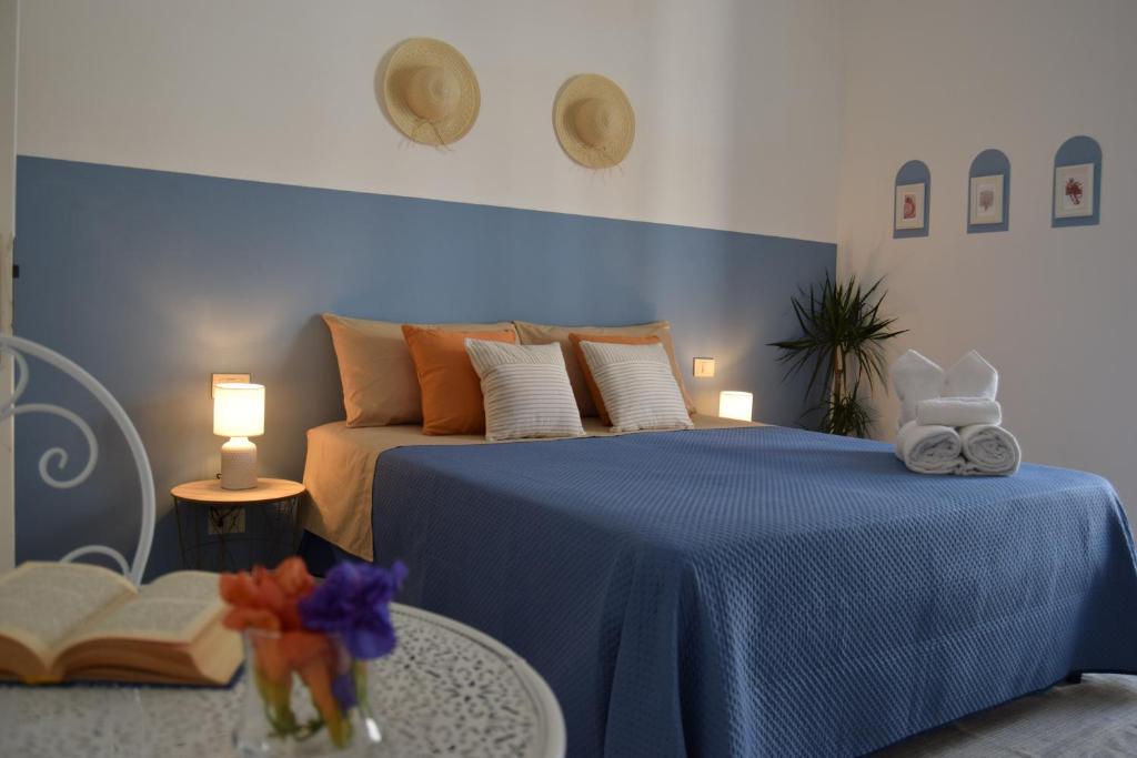 Un dormitorio con una cama azul y una mesa en Casetta nel centro storico, en Mattinata