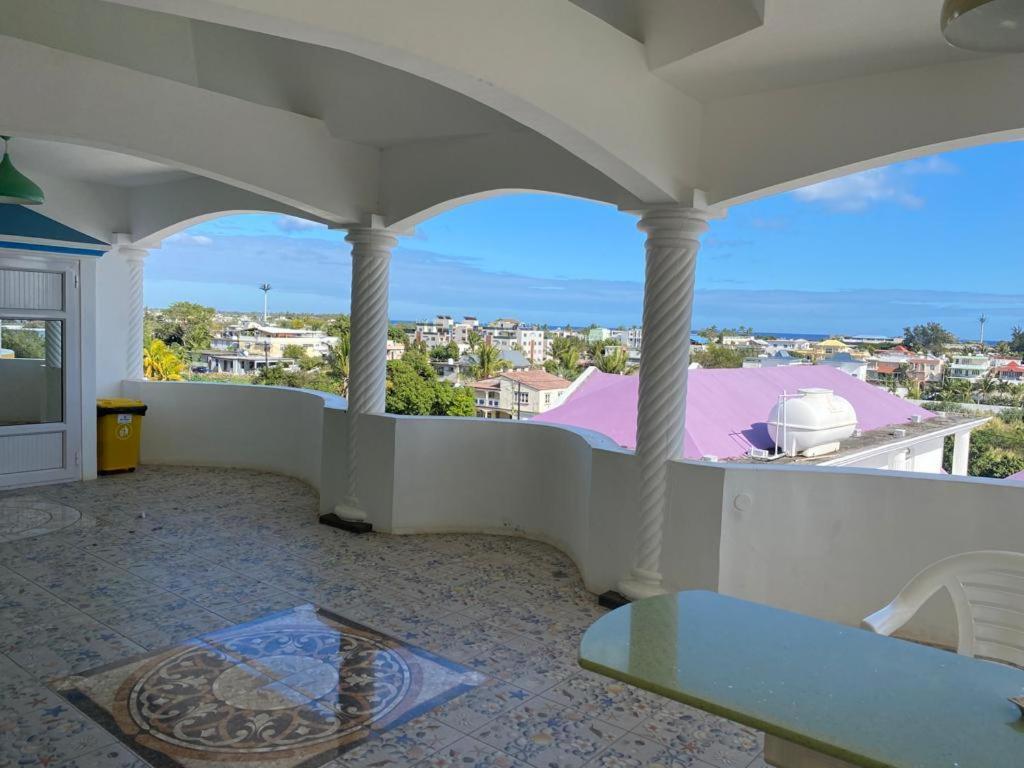 d'un balcon avec une table et une vue sur la ville. dans l'établissement Reshma appartement, à Trou aux Biches