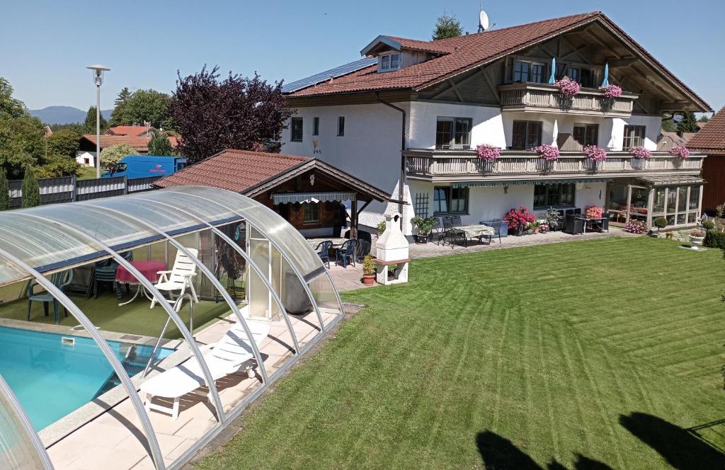 une maison avec une grande cour et une piscine dans l'établissement Ferienwohnungen König, à Bischofsmais