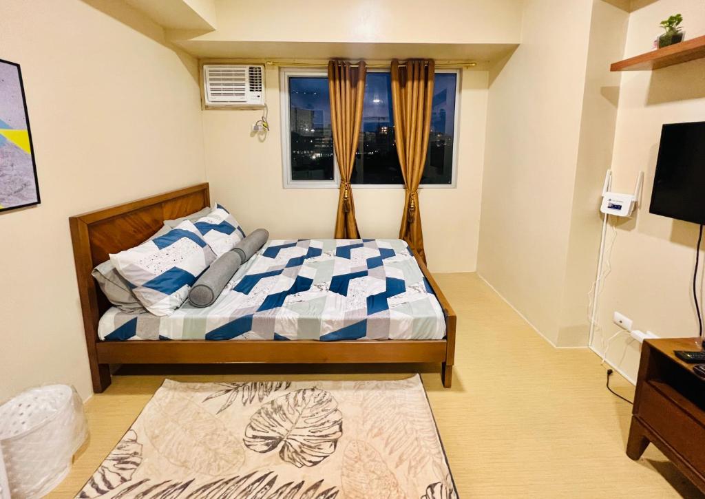1 dormitorio con cama y ventana en * * *N Affordable Urban Luxury, en Iloilo City