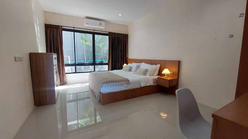 een slaapkamer met een bed en een groot raam bij Cozy Apartment Chaweng Center in Chaweng Beach