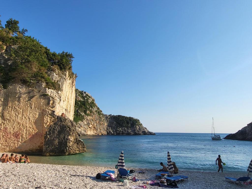 a group of people on a beach near the water at Augustus Hotel in Dhërmi