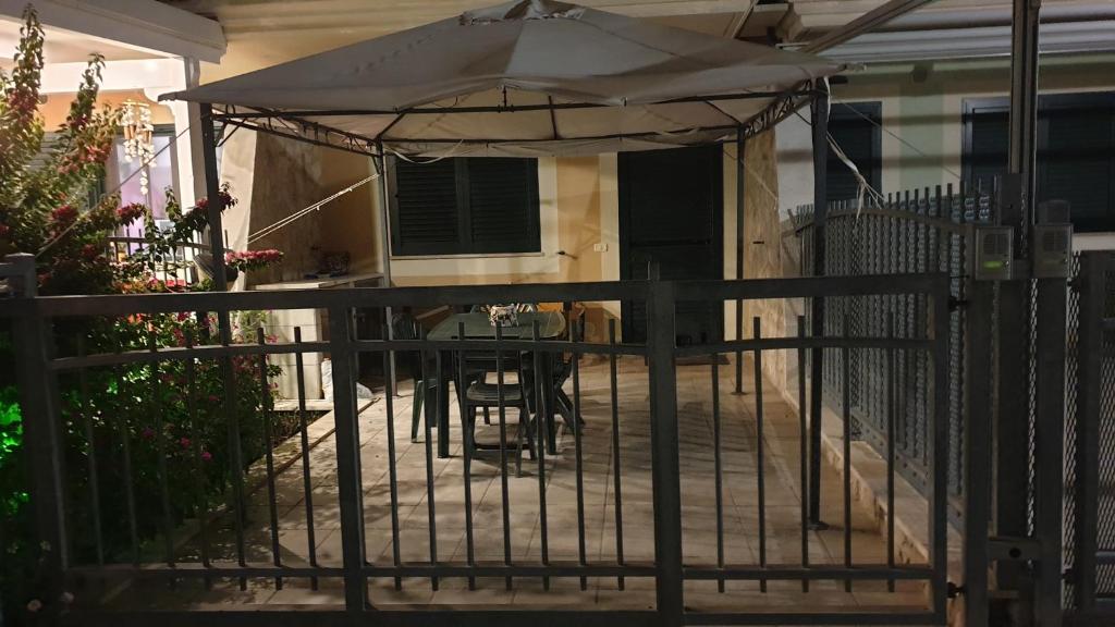 une terrasse avec un parasol et une table sur une clôture dans l'établissement Villetta in residence privato totale relax, à Campomarino