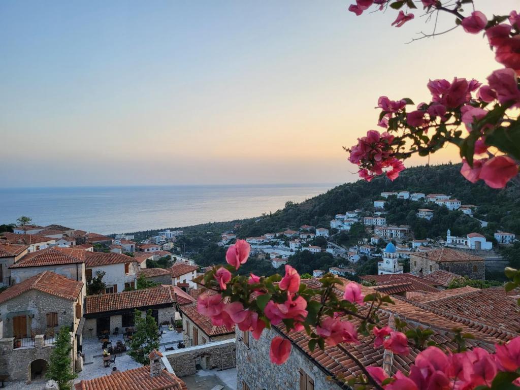 a view of a town with pink flowers at Augustus Hotel in Dhërmi