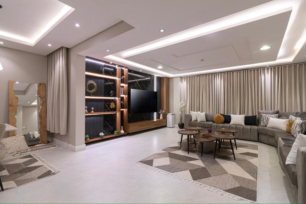 ein Wohnzimmer mit einem Sofa und einem TV in der Unterkunft كمباوند تليد - حطين - الملقا - بوليفارد in Riad