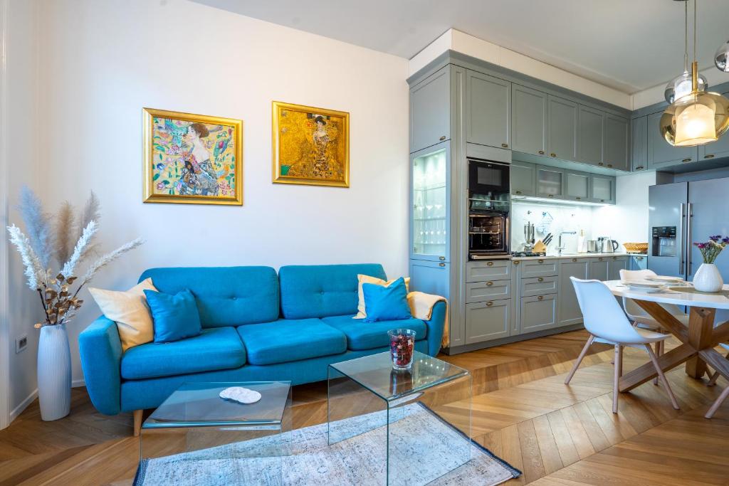 a living room with a blue couch and a table at Downtown Luxury Retreat in Ljubljana