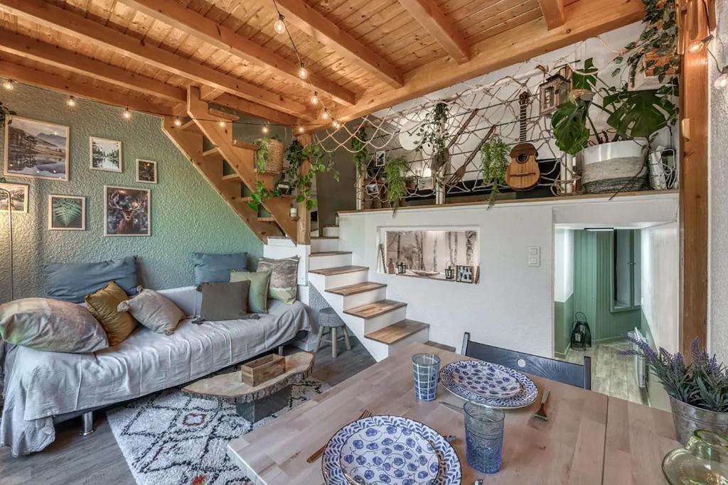 a living room with a couch and a staircase at Cabane pour vos vacances à 190m du lac d’Annecy in Menthon-Saint-Bernard