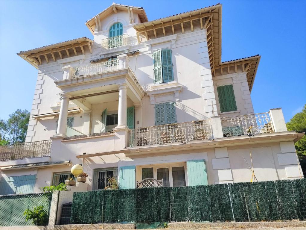 濱海薩納里的住宿－La Bastide, 100m des rues piétonnes, jardin，前面有栅栏的大白色房子