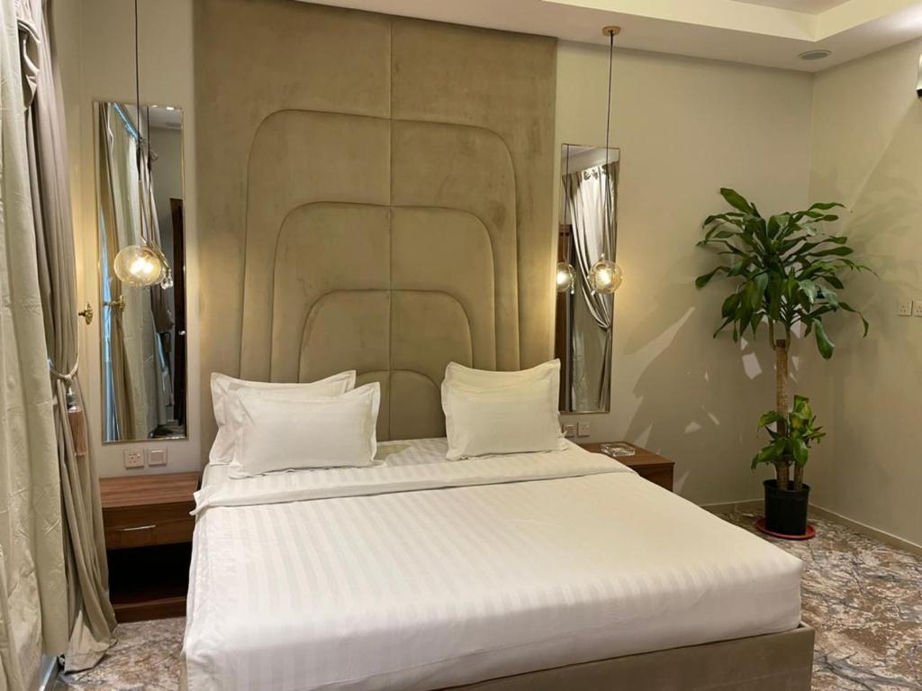 a bedroom with a large bed with white sheets at شاليهات دار الورد in Taif