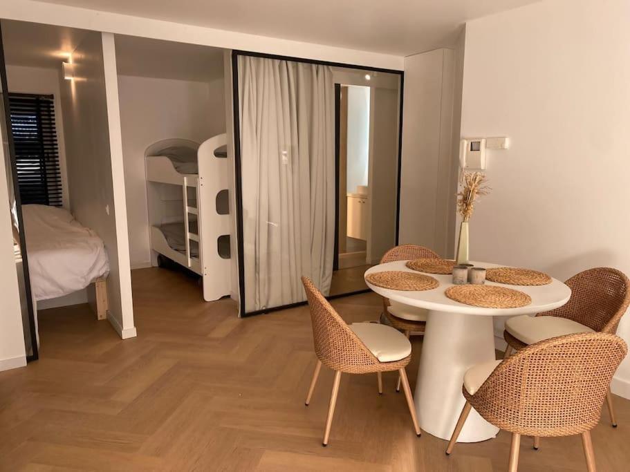 a room with a table and chairs and a bedroom at Klein geluk te Nieuwpoort. in Nieuwpoort