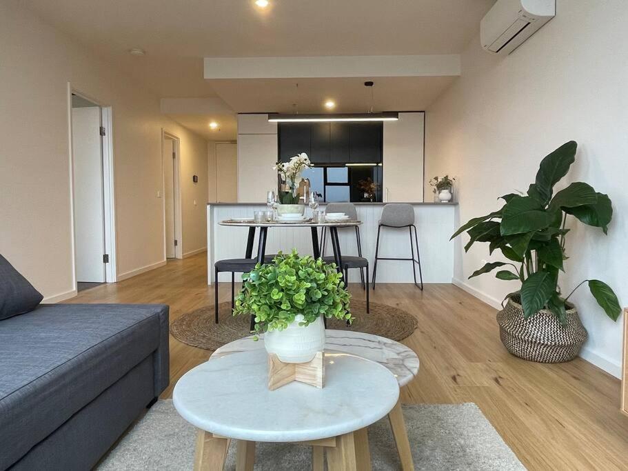 a living room with a couch and a table with plants at Brand new 1BR apartment Dickson in Canberra