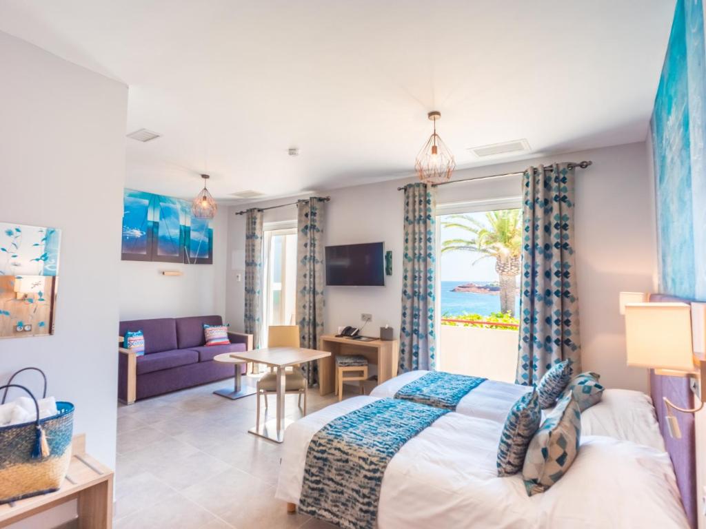 TV a/nebo společenská místnost v ubytování Hôtel et Appart Hôtel Les Flots Bleus