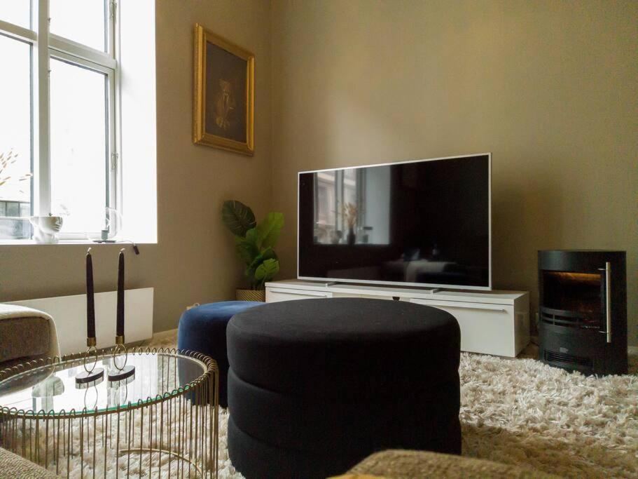 salon z telewizorem, krzesłem i stołem w obiekcie Central and modern apartment in Oslo w Oslo
