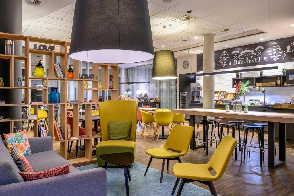 a restaurant with chairs and a table and a bar at Holiday Inn Express Mechelen City Centre, an IHG Hotel in Mechelen