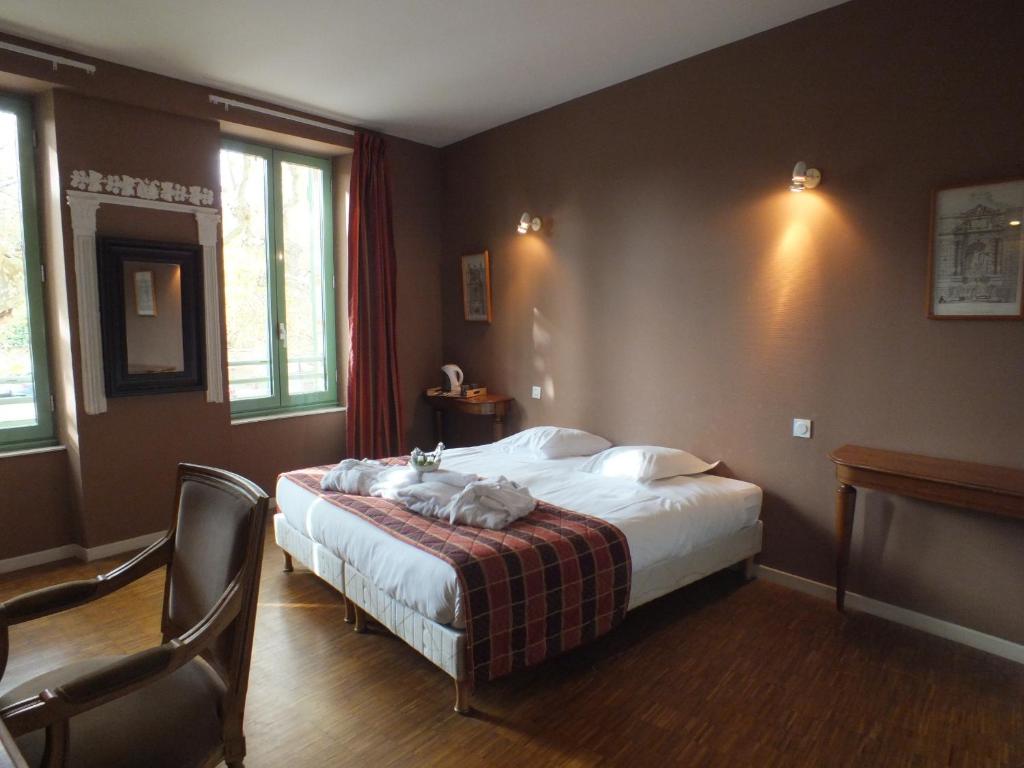 Schlafzimmer mit einem Bett, einem Tisch und Stühlen in der Unterkunft Hôtel De L'Horloge in Auvillar