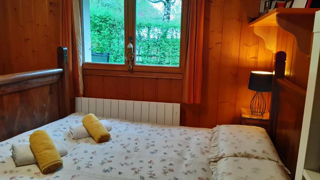 um pequeno quarto com uma cama e uma janela em TellaHouse em Chamonix-Mont-Blanc