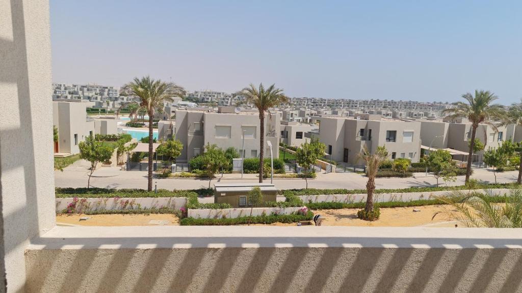 uitzicht vanaf het balkon van een gebouw met palmbomen bij Azha ain sokhna luxury chalet - families only - 155sqm special weekly monthly rates in Ain Sokhna