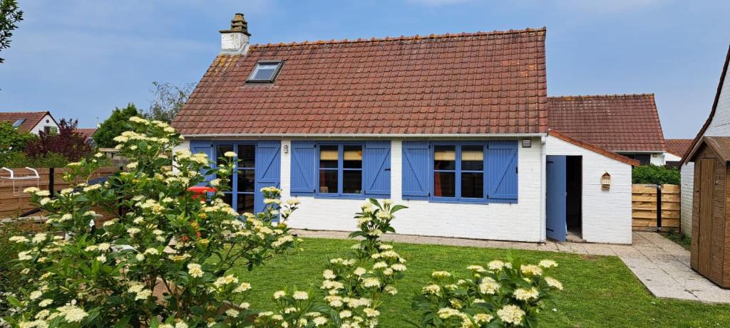 una casa blu e bianca con tetto marrone di Polderrust a De Haan
