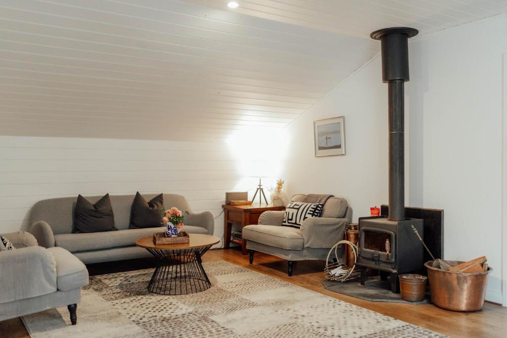 a living room with two couches and a fireplace at MARYBANK ESTATE - BARN LOFT in Montacute