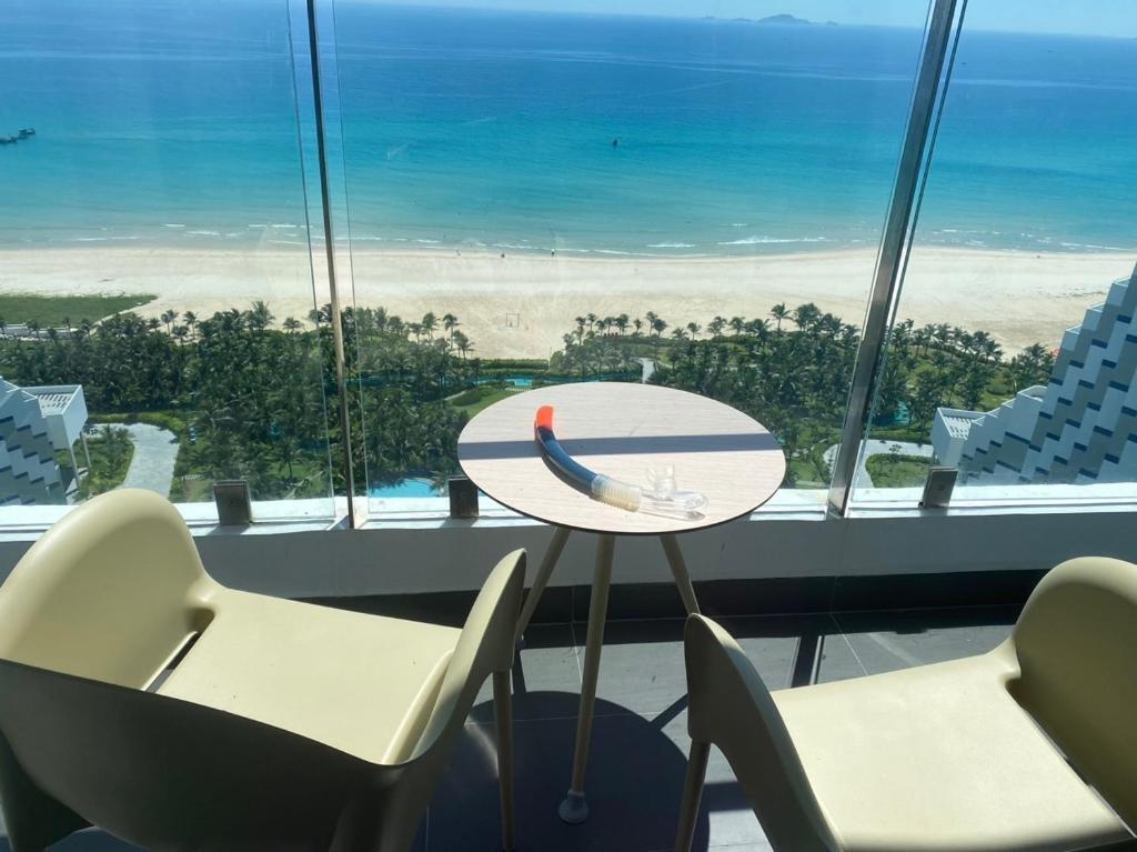 a table and chairs in a room with a view of the ocean at Ocean view at The Arena Cam Ranh resort, Bai Dai beach - near Airport Nha Trang, Khanh Hoa in Cam Lâm