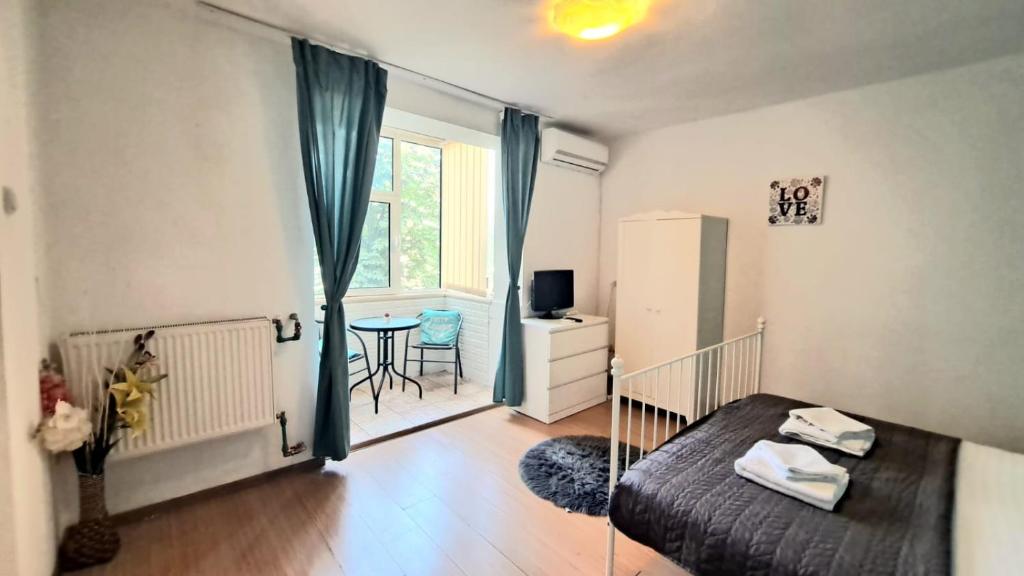 een slaapkamer met een bed, een tafel en een raam bij Închiriez garsoniera în regim hotelier unirii in Boekarest