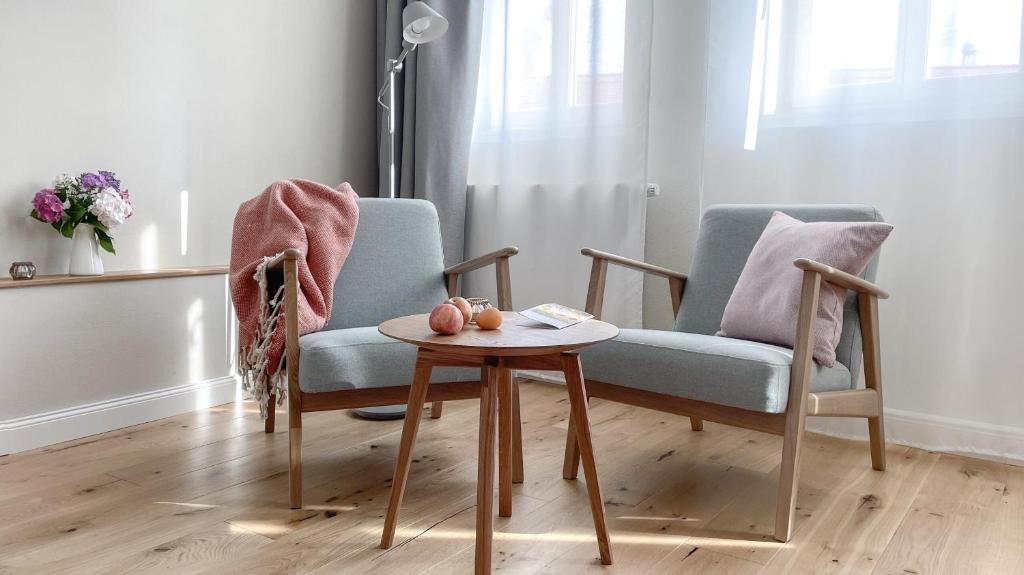 ein Wohnzimmer mit einem Stuhl und einem Tisch in der Unterkunft Apartments am Dom in Naumburg