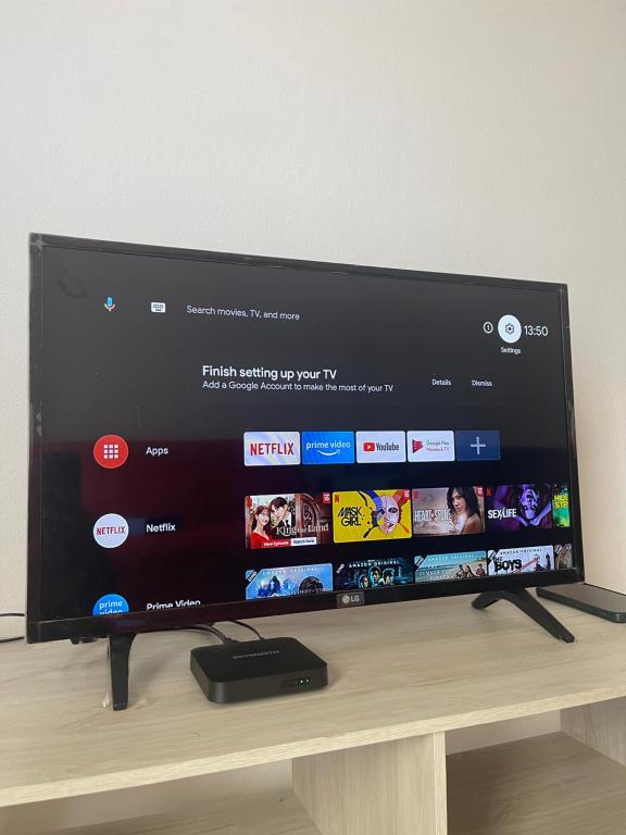 a flat screen tv sitting on top of a wooden table at Homestay CikguMa - Netflix & Wifi in Kota Bharu