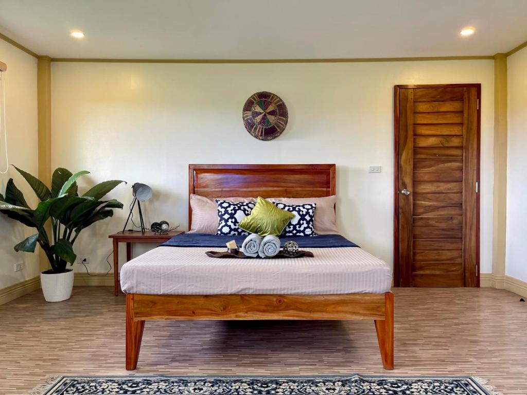 a bedroom with a bed with a wooden head board at Beautiful 2BD Farmhouse for 4-10 pax in Ormoc