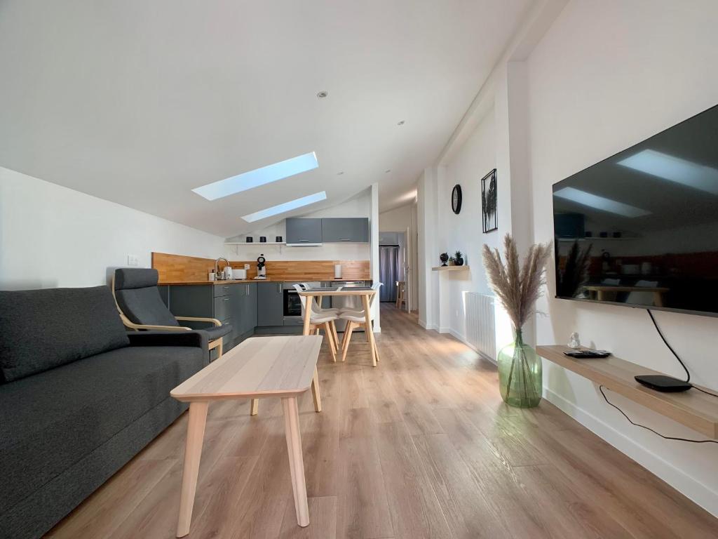 a living room with a couch and a table at Appartement cosy avec parking in Dinsheim