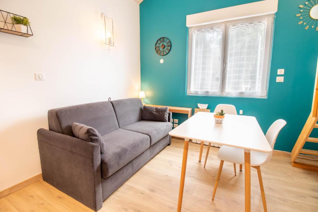 a living room with a couch and a table at Studio duplex, proche université in Montbéliard