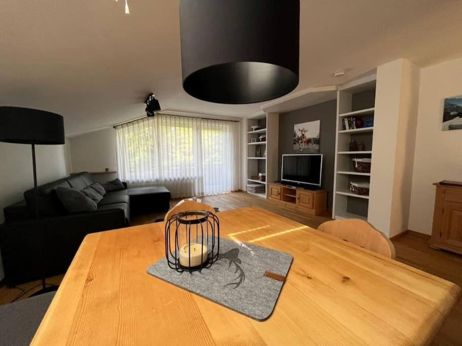 ein Wohnzimmer mit einem Holztisch mit einer Lampe in der Unterkunft Ferienwohnung Erika in Oberstdorf