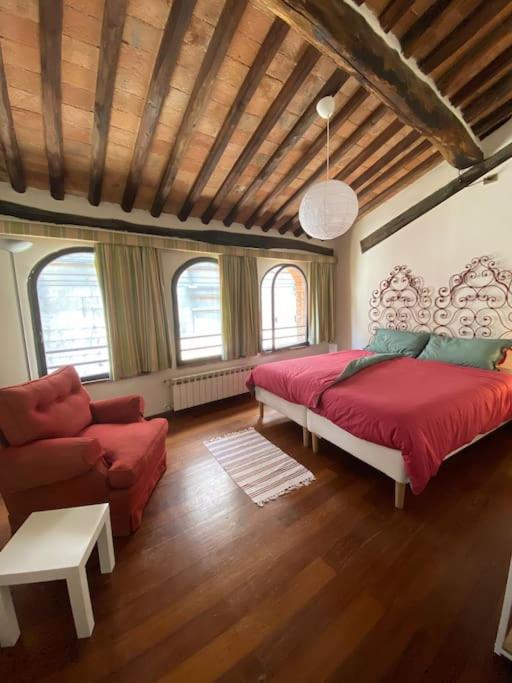 a bedroom with a bed and a couch and a chair at Alle Casine in Lucca