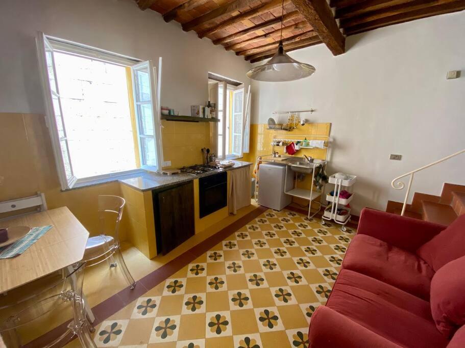 a living room with a red couch and a kitchen at Alle Casine in Lucca