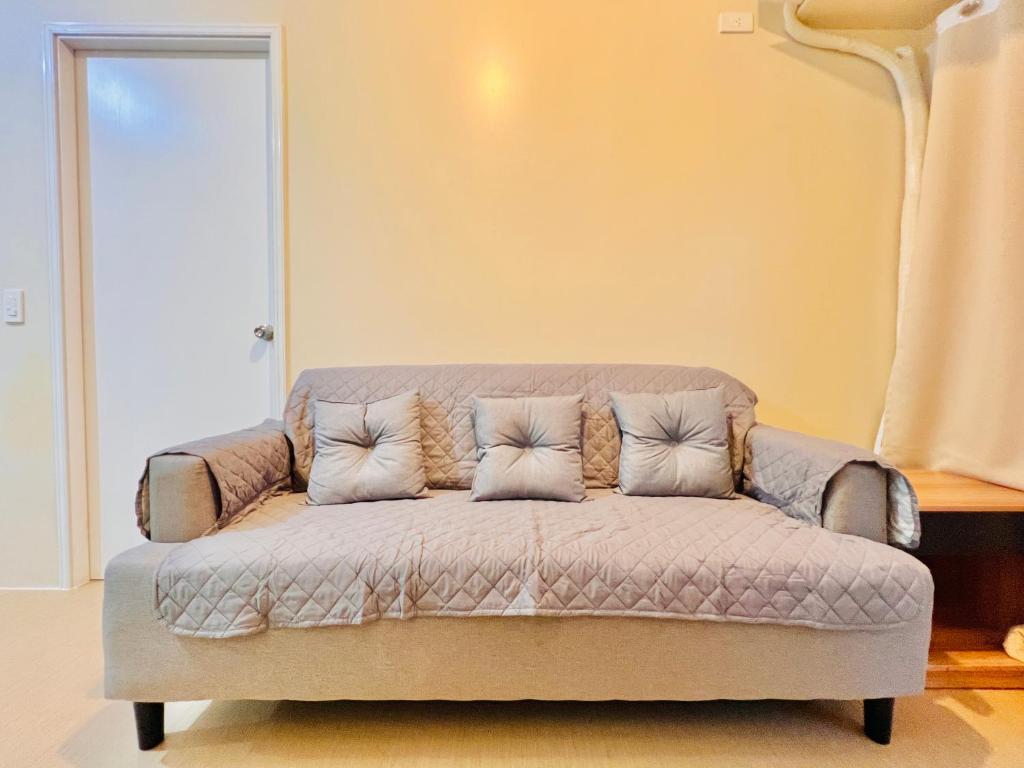 un sofá con 4 almohadas en una habitación en * *M Your Iloilo City Sanctuary, en Iloilo City