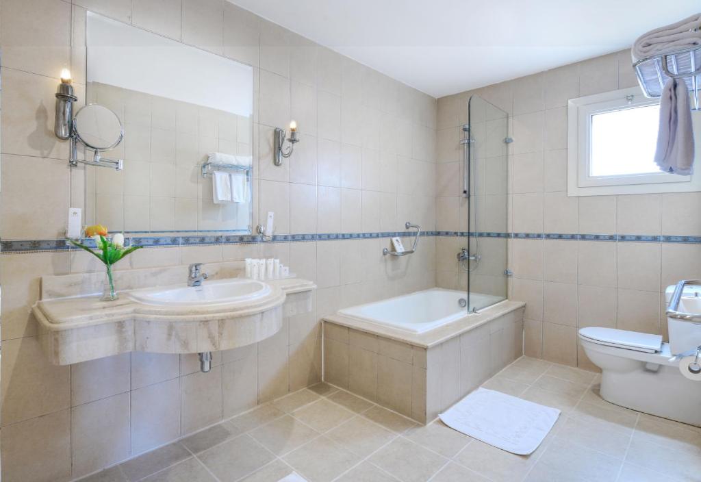 a bathroom with a tub and a sink and a toilet at Tolip Aswan Hotel in Aswan
