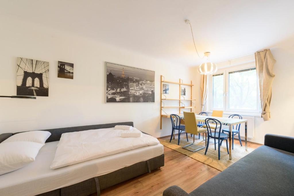 sypialnia z łóżkiem, stołem i krzesłami w obiekcie Vienna Lights Apartments - Apartment Park View w Wiedniu