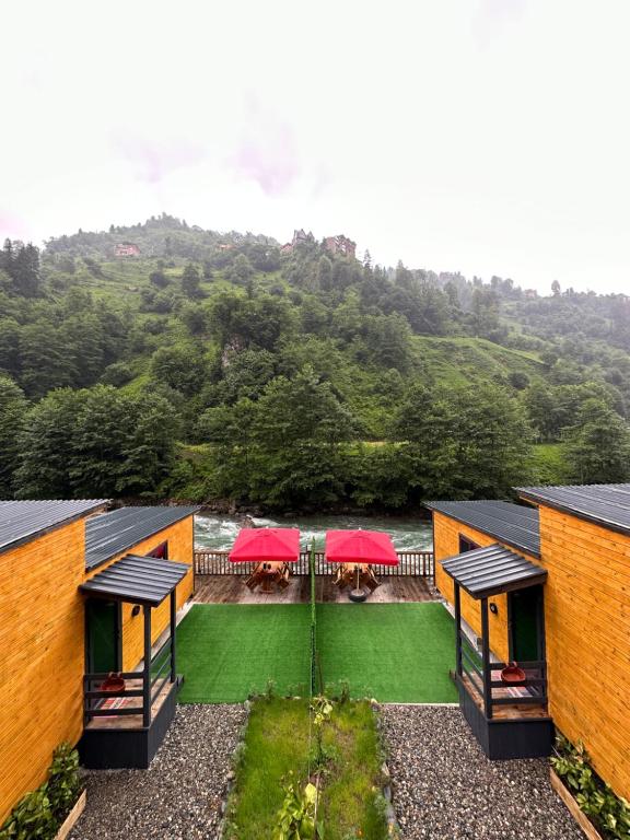 an aerial view of a building with tables and red umbrellas at Nayon Tiny House in Rize