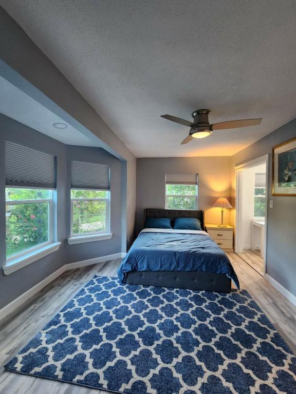 1 dormitorio con cama azul y alfombra azul en Spacious Bedroom with private workspace, ensuite bathroom - Room# 1 in SHARED house NO PET en Orlando